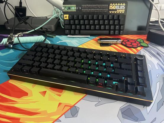 An Epomaker mechanical keyboard sitting in front of a bare custom keyboard PCB.